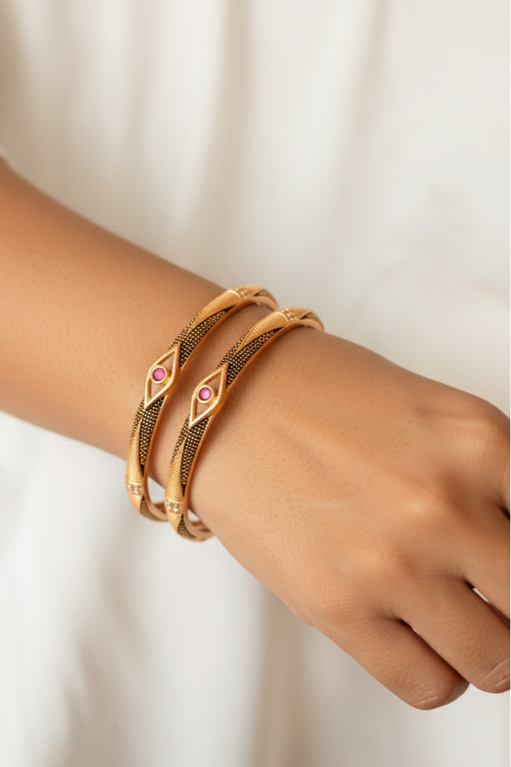 Elegant Golden Bangles with Black Detailing & Pink Stone Centerpiece