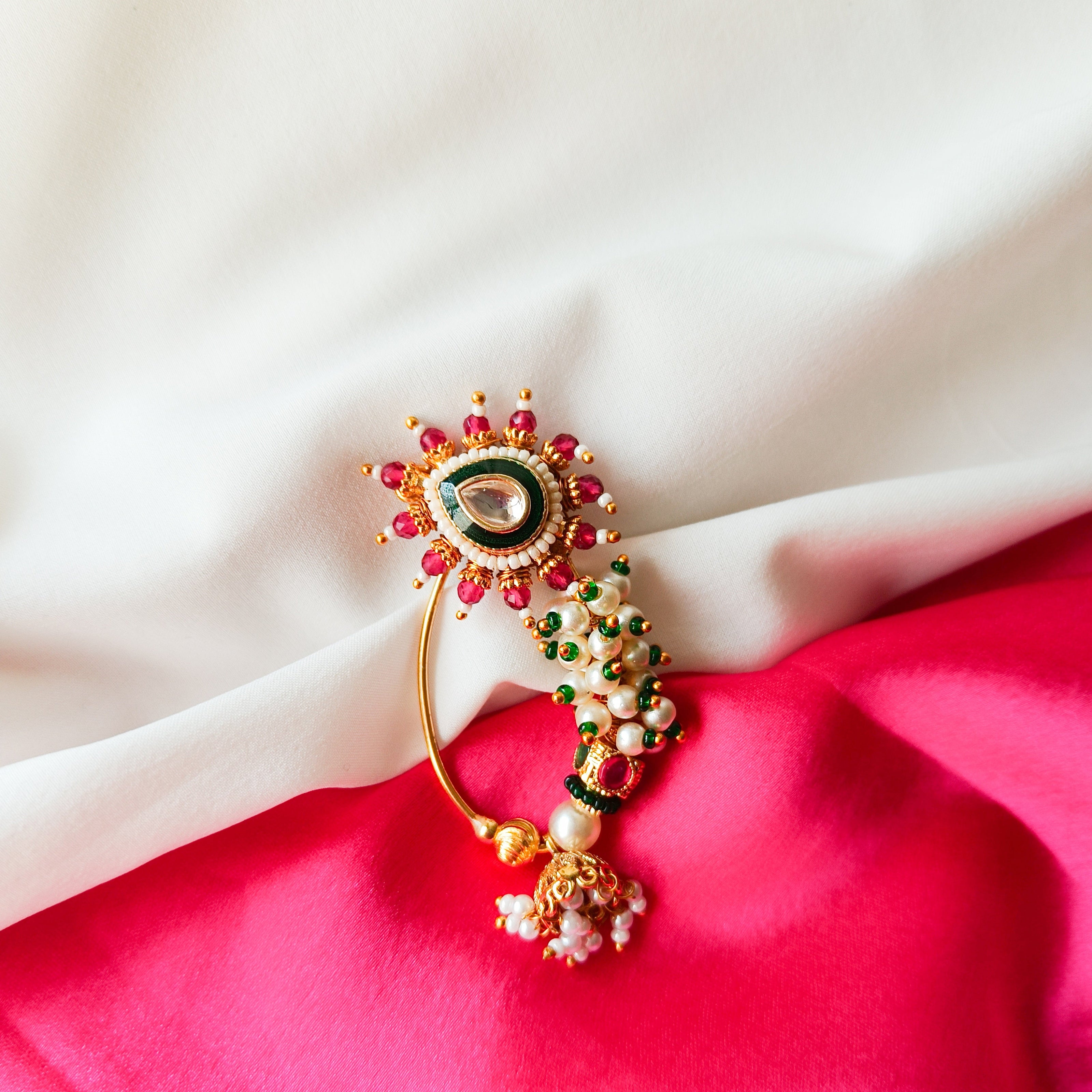 Decorative hairpin with gemstones on a red and white fabric background