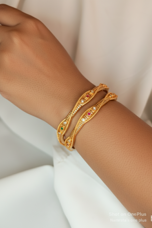 Gold bracelet with embedded stones on a wrist against a neutral background