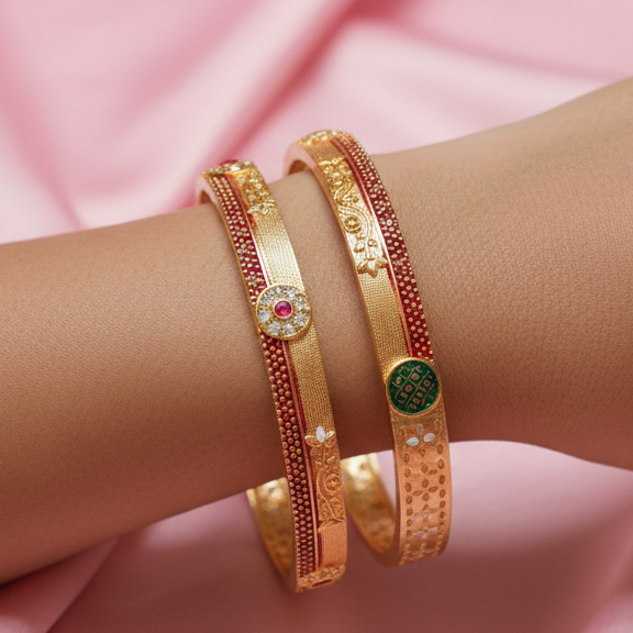 Gold bangles with embedded stones on a pink fabric background