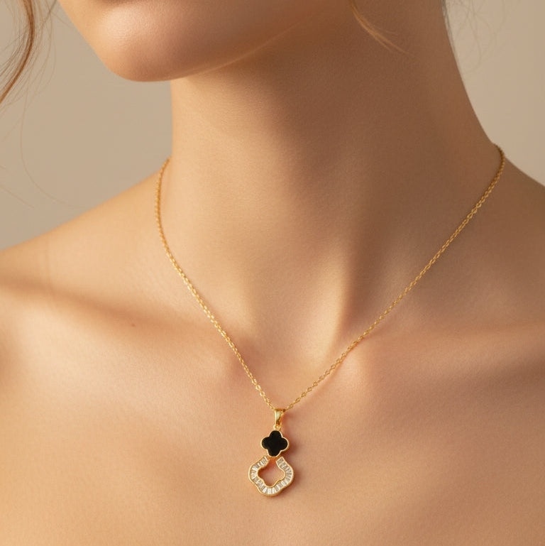 Close-up of a woman wearing a gold necklace with a black pendant on a beige background